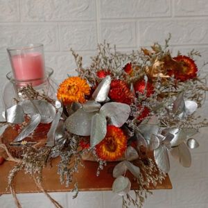 Centro de mesa navideño con rosas suaves, piñas doradas y acentos azules