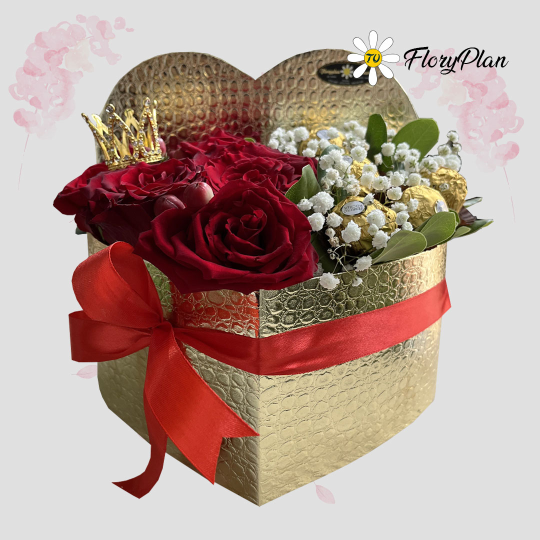 Caja dorada en forma de corazón con rosas rojas y bombones finos.