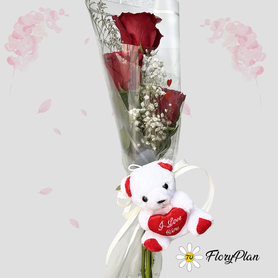 Tres rosas con un pequeño oso de peluche en color blanco y rojo.